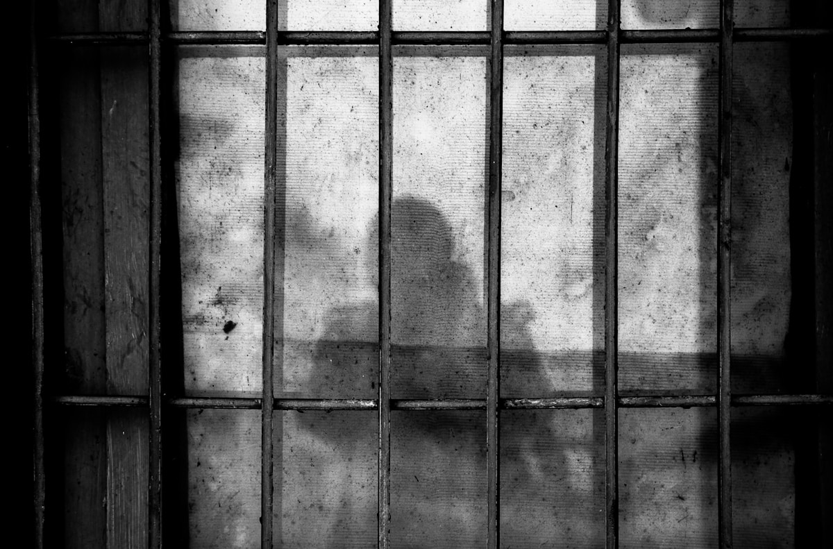 Silhouette behind prison bars